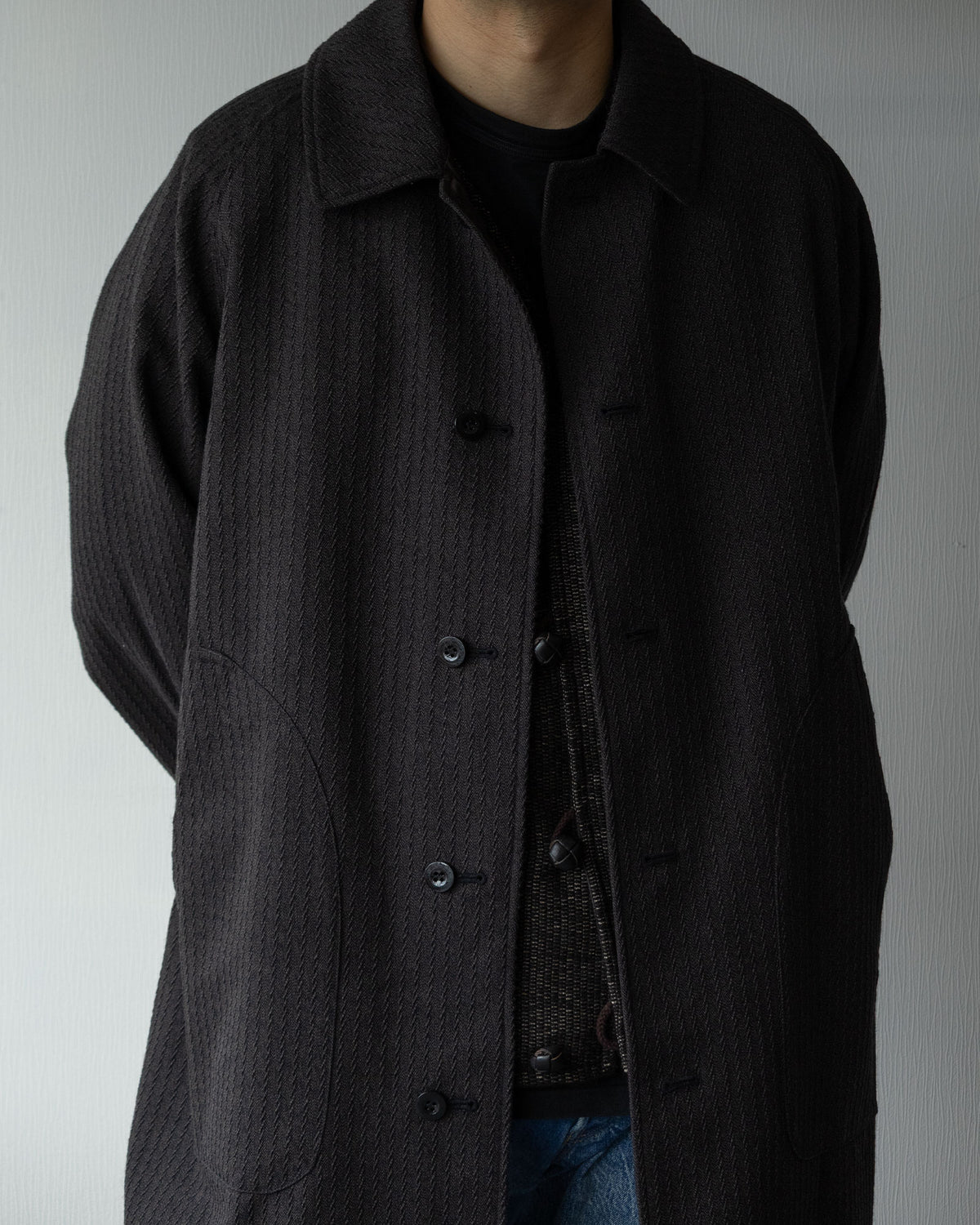 OUTILのリバーシブルコート「MANTEAU CHAMBON」チャコールカラーの着用イメージ。