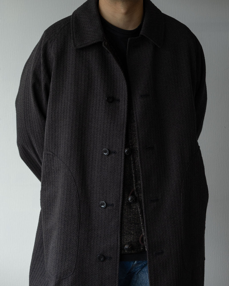 OUTILのリバーシブルコート「MANTEAU CHAMBON」チャコールカラーの着用イメージ。