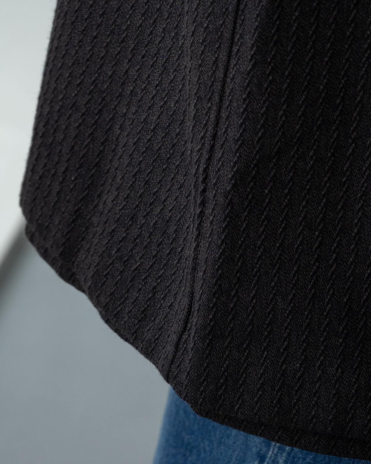 OUTIL MANTEAU CHAMBONのチャコールカラー表面。綿の撚杢とウールを使用したドビー組織のストライプ生地のアップ。